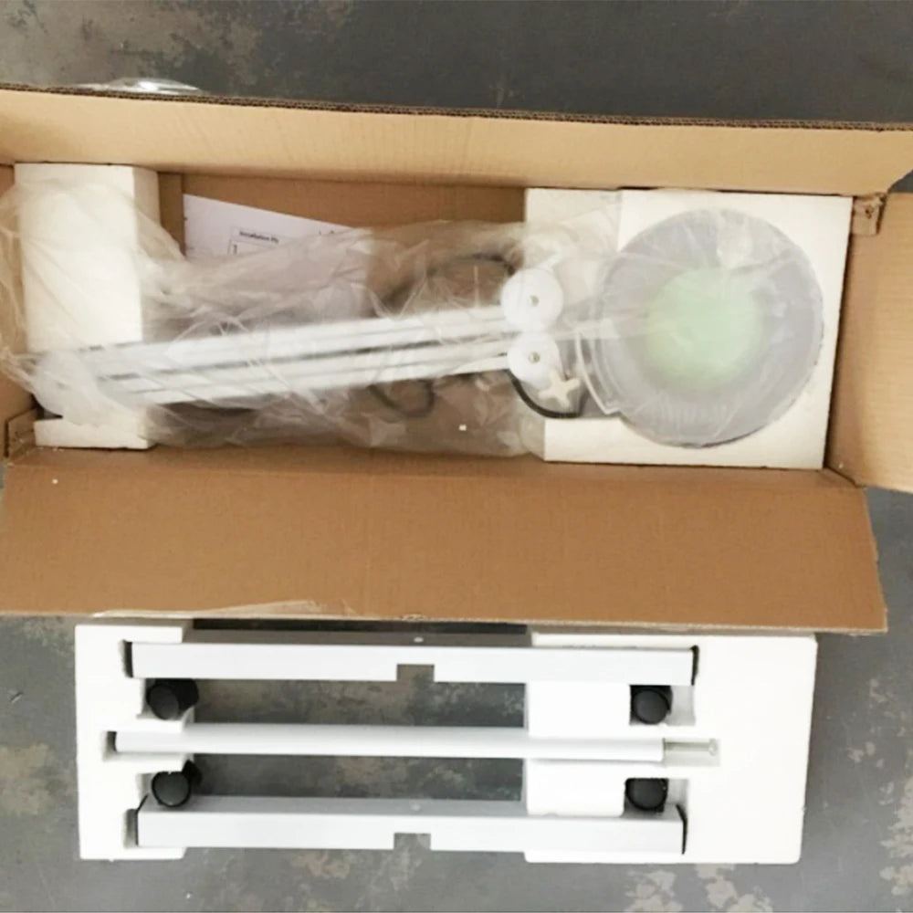 Unassembled shower head and arm set in a cardboard box on a gray surface.