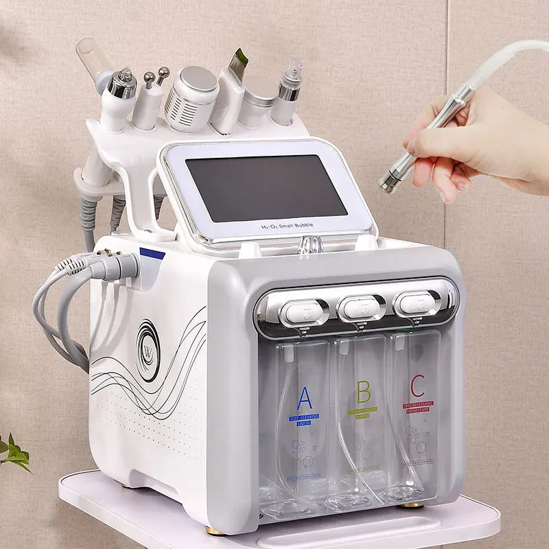 Beauty device with multiple attachments and a hand holding one, against a neutral background.